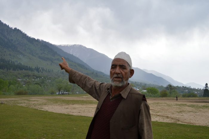 A Kashmiri man near a Budgam forest shows the degradation caused to forests over the past few decades [image by: Athar Parvaiz]