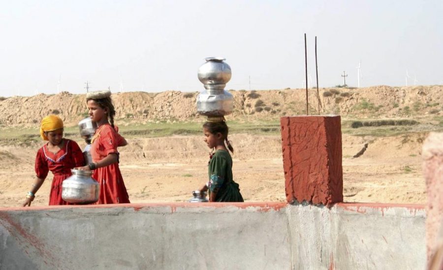 Young girls at a well in Gujarat, which is already facing a water scarcity [image by: Mark Charmer]