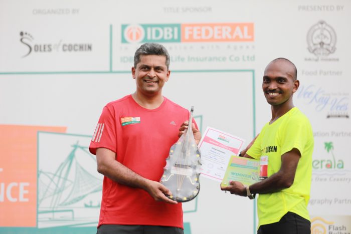Karthik Raman, CMO, IDBI Federal Life Insurance felicitating the winner of the Full Marathon, Mahesh P S at the IDBI Federal Life Insurance Spice Coast Marathon 2018