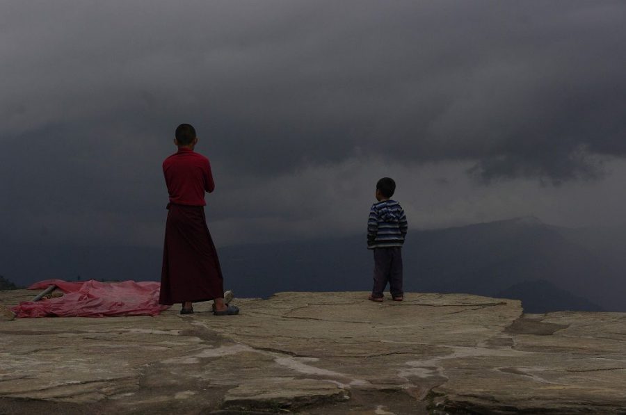 A monk and child stare at an approaching storm at Sanga Choling monastery in Sikkim, India. Should states such as these be compensated for protecting the climate? [image by Andrea Kirkby]