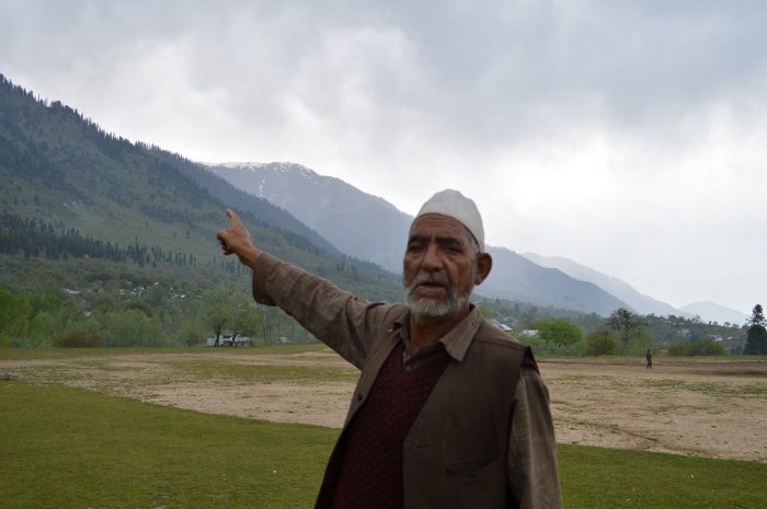 A Kashmiri man near a Budgam forest shows the degradation caused to forests over the past few decades [image by: Athar Parvaiz]